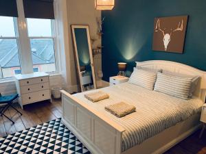 um quarto com uma cama branca e uma cabeça de veado na parede em Bridge View Apt - stunning River Tay views em Fife