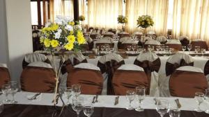 a banquet hall with tables and chairs with flowers on them at Motel Balcost in Piatra Neamţ
