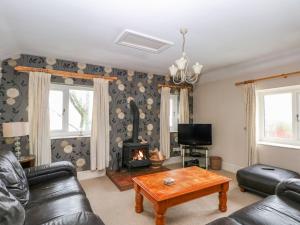 a living room with a table and a fireplace at Bowden Head Farmhouse Cottage in Highpeak Junction