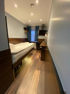 een ziekenhuiskamer met een bed en een bureau bij Crestfield Hotel in Londen