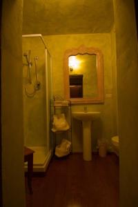 ein Bad mit einem Waschbecken und einem Spiegel in der Unterkunft Locanda Guelfo in Tredozio