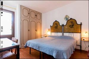 a bedroom with a large bed with a blue blanket at Casa Sulky SantAntioco in Maladroscia