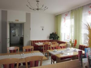 ein Restaurant mit Tischen und Stühlen und einem Fenster in der Unterkunft Pension Elisabeth in Sankt Pölten