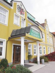 ein gelbes Gebäude mit einem Schild, das Pensiononlez liest in der Unterkunft Pension Elisabeth in Sankt Pölten