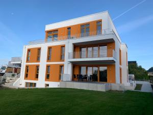 un edificio naranja con césped delante en Urban Apartement-Boardinghouse Wadersloh, en Wadersloh