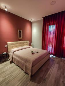 um quarto com uma cama grande e paredes vermelhas em B&B Le Canapine em Frattamaggiore
