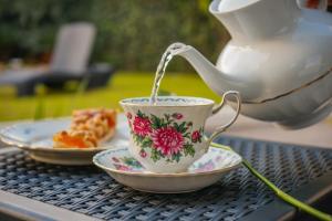 a teapot pouring tea into a cup on a table at B&B Le Canapine in Frattamaggiore