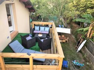 a backyard with a deck with couches and a table at Location Seignosse in Seignosse