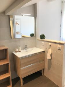 ein Bad mit einem Waschbecken und einem Spiegel in der Unterkunft Location Seignosse in Seignosse