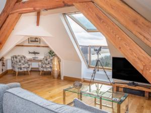 an attic living room with a large window at Nyth y Fran in Menai Bridge