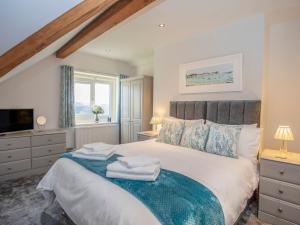 a bedroom with a large bed with towels on it at Nyth y Fran in Menai Bridge