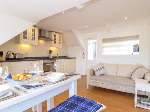 a kitchen and living room with a table and a couch at The Loft at Beach House in St Austell