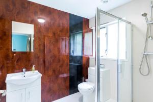 a bathroom with a toilet and a glass shower at Abbeyfield Lodge in Stockton-on-Tees
