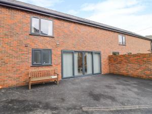 a brick building with a bench in front of it at 7evern Porth Farm in Caersws