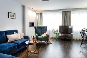 un soggiorno con divano blu e TV di Apartamenty Stare Miasto Szczecin LD a Stettino