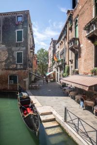 Una góndola estacionada junto a un canal en una ciudad en Dimora Al Doge Beato vista canale, en Venecia