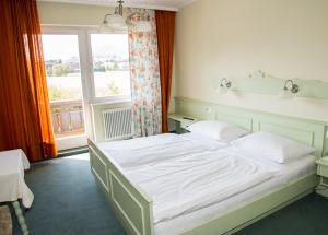 Schlafzimmer mit einem weißen Bett und einem Fenster in der Unterkunft Gasthof-Hotel Jaritz in Semriach