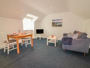 a living room with a table and a couch at Summer Breezes in Newquay