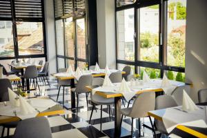 a restaurant with tables and chairs and windows at Villa Ljiljana in Vinkovci