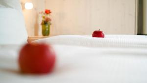 Una manzana roja sentada encima de una cama en Hotel Bergamo en Ludwigsburg