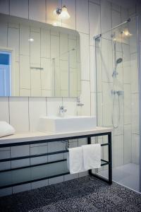 W łazience znajduje się umywalka oraz prysznic z lustrem. w obiekcie Villa Ljiljana w mieście Vinkovci