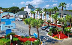 a hotel with a sign and palm trees in a parking lot at Admiral's Inn on Tybee Island in Tybee Island