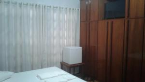 a bedroom with a bed and a dresser with a television at Central 1 in Uruguaiana