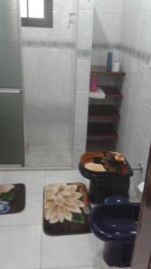 y baño con aseo azul y ducha. en Central 1 en Uruguaiana