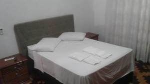 ein Schlafzimmer mit einem Bett mit zwei Handtüchern darauf in der Unterkunft Central 1 in Uruguaiana