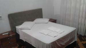 a bedroom with a bed with two towels on it at Central 1 in Uruguaiana