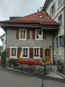 a house with red flowers in front of it at Le fer à cheval in Montreux