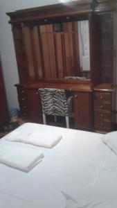um quarto com uma cama branca e uma secretária. em Central 1 em Uruguaiana
