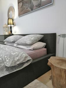 a bed with pillows and a table in a room at Apartament Rondo in Trzebinia