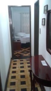 ein Zimmer mit einem Tisch und ein Schlafzimmer mit einem Bett in der Unterkunft Central 1 in Uruguaiana
