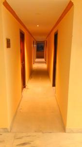 an empty hallway with orange walls and a long corridor at Hotel Ramco Residency A/c in Kanchipuram