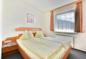 Schlafzimmer mit einem großen Bett und einem Fenster in der Unterkunft Gasthof Neuwirt in Schöder