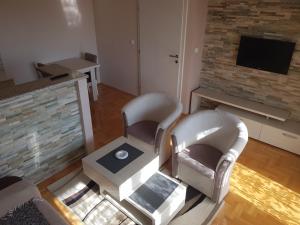 un soggiorno con 2 sedie e una TV di Sunce a Šabac