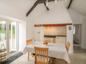 cocina con mesa y sillas y cocina con ventana en The Old White Cottage, en Shillelagh