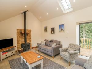 a living room with a couch and a fireplace at The Milking Barn in Yeovil