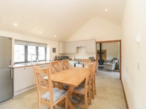 a kitchen with a wooden table and some chairs at The Milking Barn in Yeovil