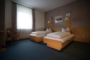 a hotel room with two beds and a window at Hotel Waldfrieden in Emmelshausen