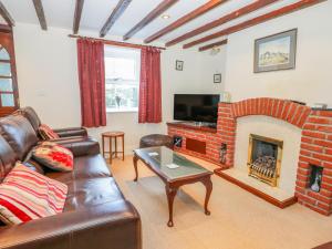 sala de estar con sofá y chimenea en Dove Cottage en Whitby