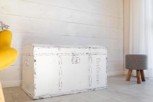 a white wooden box in a room with a chair at Sandkasten 6 in Norddeich +64 photos