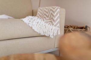 a white blanket sitting on top of a couch at Sandkasten 6 in Norddeich