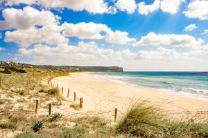 une plage de sable avec une clôture et l'océan dans l'établissement Apartamentos Mar Blau, à Son Bou