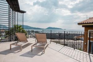 a balcony with two chairs and a view of the ocean at Teetara Villa Patong in Patong Beach
