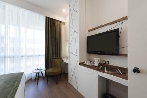Habitación de hotel con cama, TV y escritorio. en ISG Sabiha Gökçen Airport Hotel en Estambul