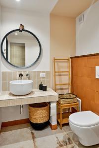 bagno con lavandino, servizi igienici e specchio di Casa Capasa a Bari