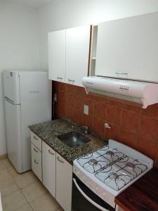 uma cozinha com um fogão e um lavatório em Departamentos Carbó em Paraná