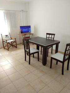 uma mesa de jantar com 2 cadeiras e uma televisão em Departamentos Carbó em Paraná